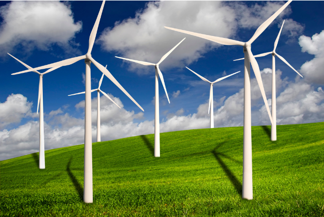 Wind turbines on a hilly grass field.