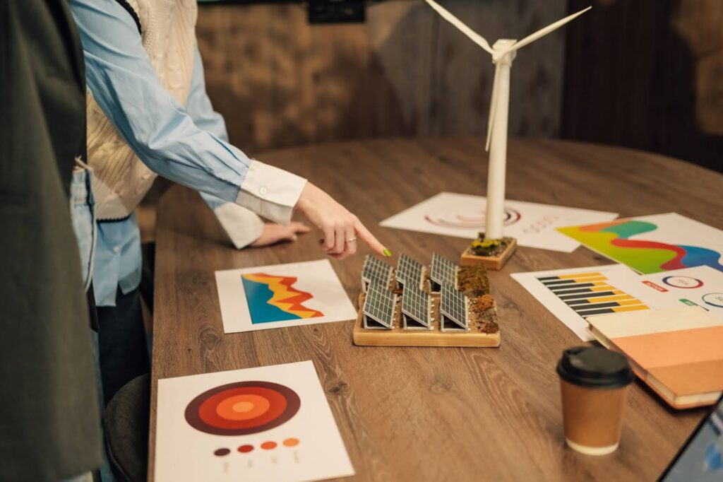 Woman pointing at a model of solar panels on a table.