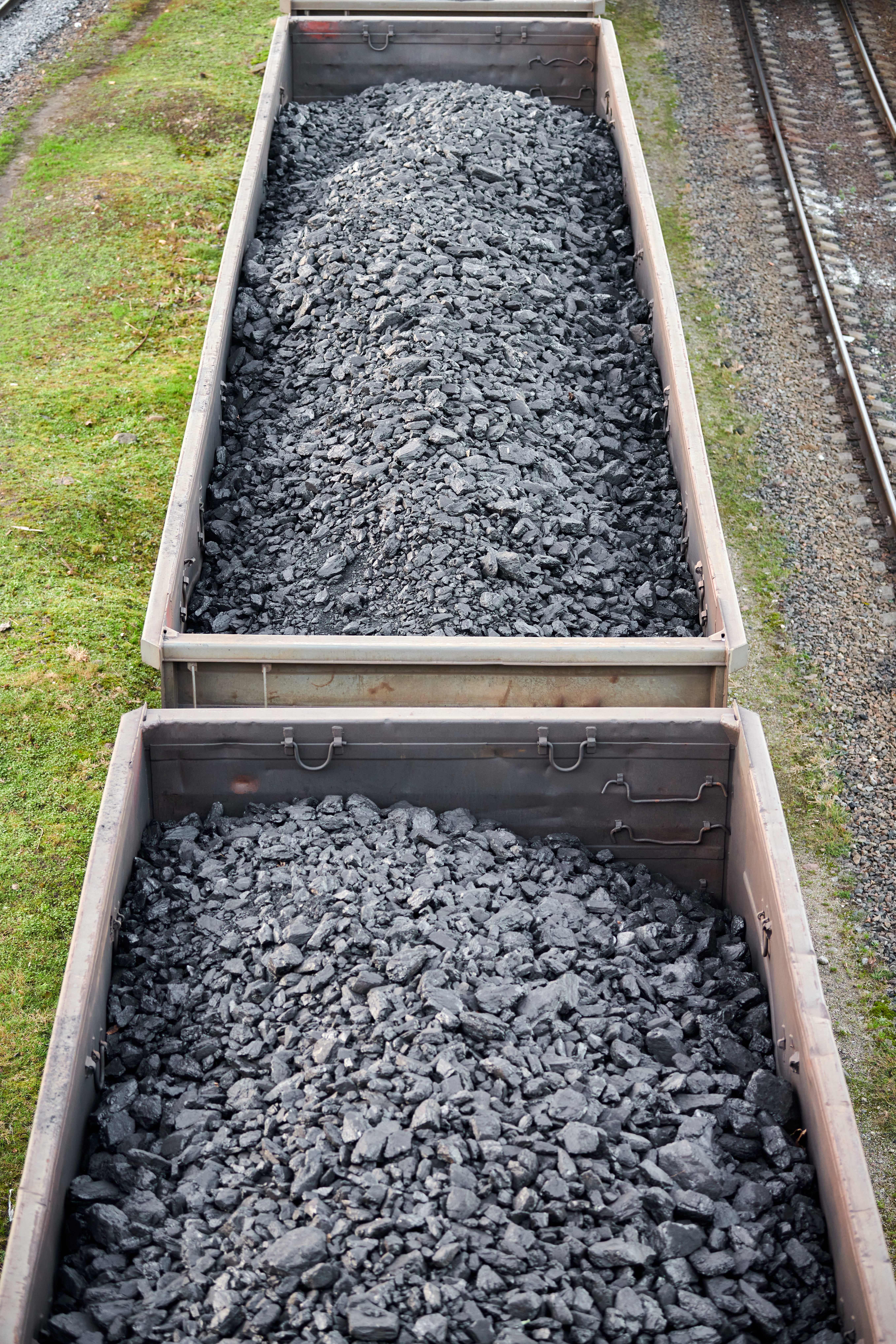 Railway cargo cars loaded with coal. Freight train transporting coal, wood, fuel. Top view.