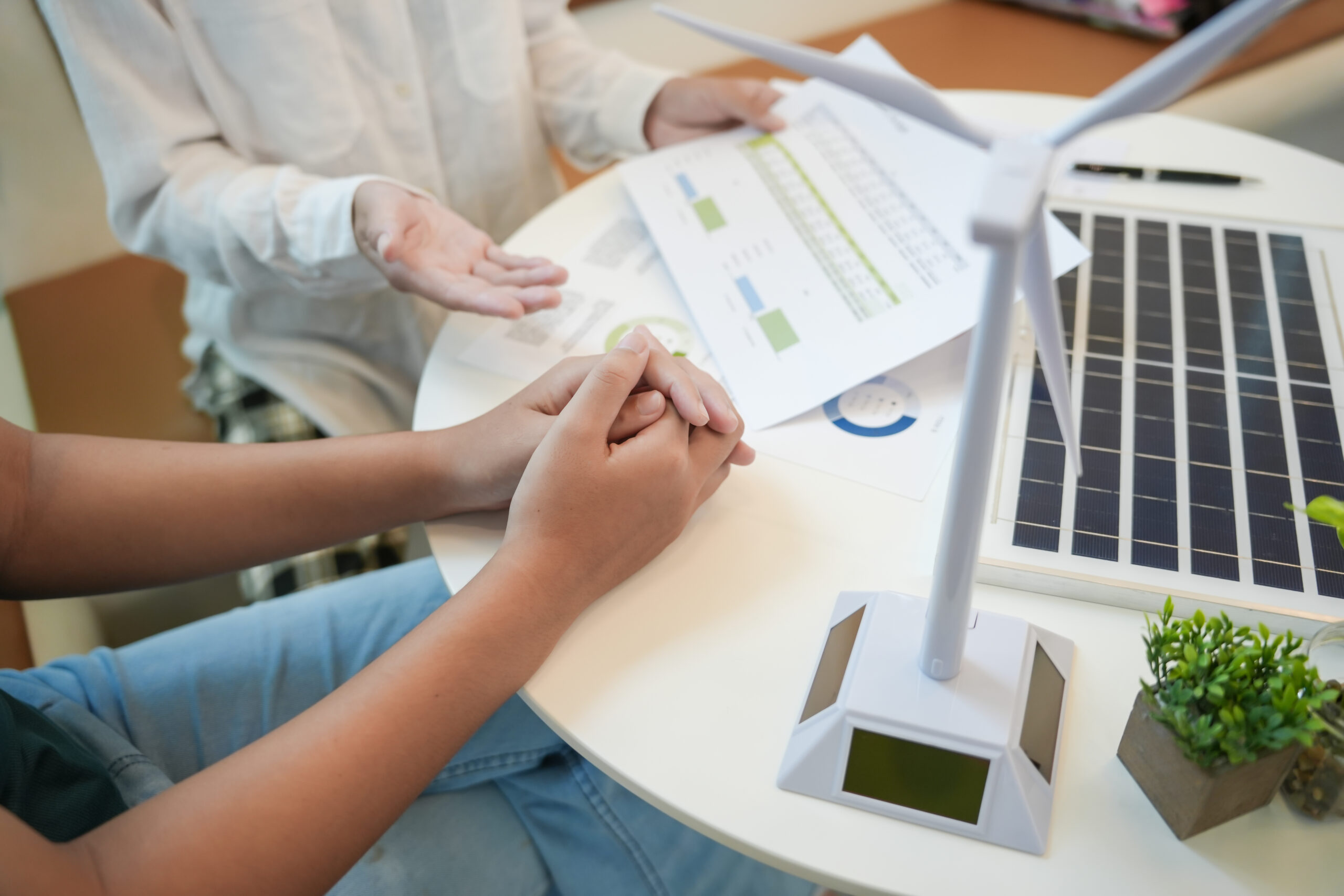 Students at a table discussing solar power and wind power.